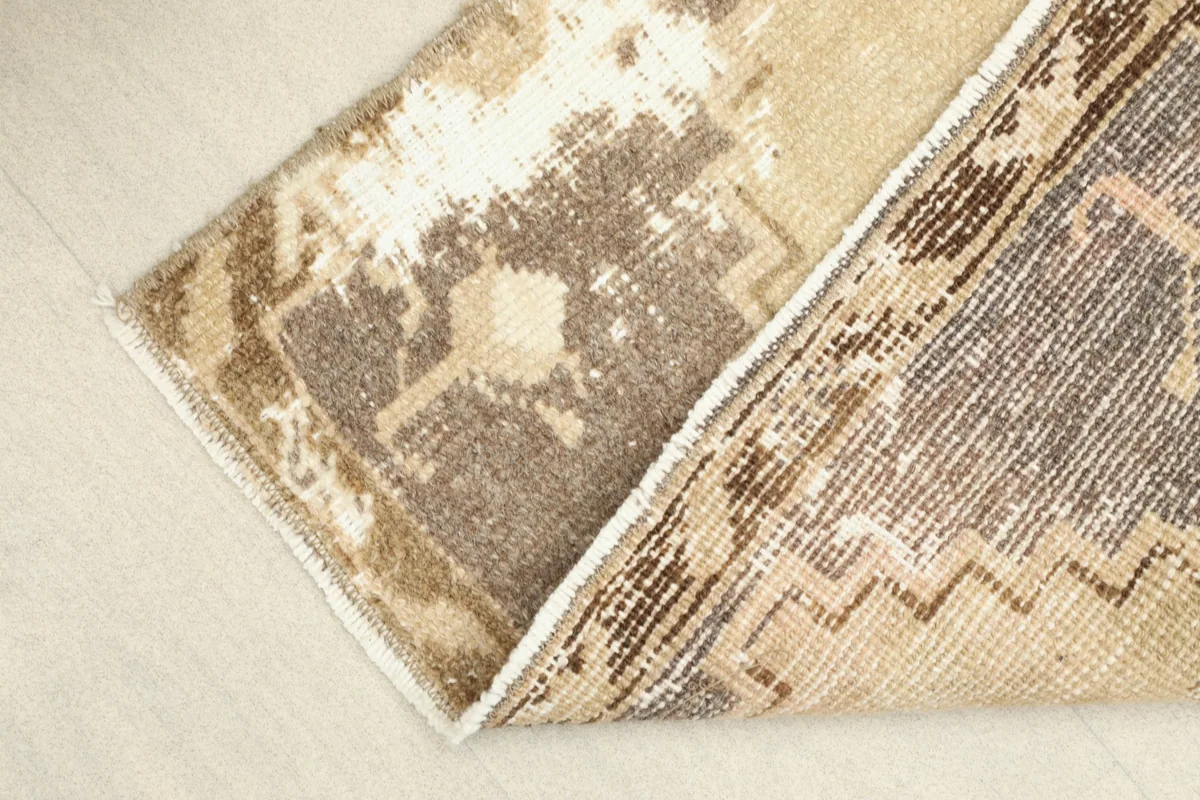 Folded rug showing the reverse side and the texture of the hand-knotted wool pile and cotton foundation.