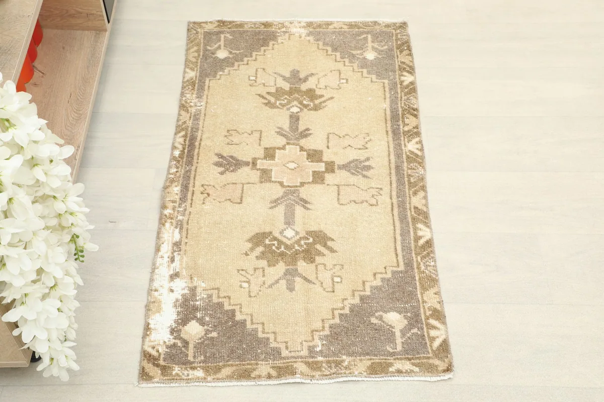 Overhead view of the vintage Anatolian rug, showcasing its tan field and brown tribal geometric patterns.
