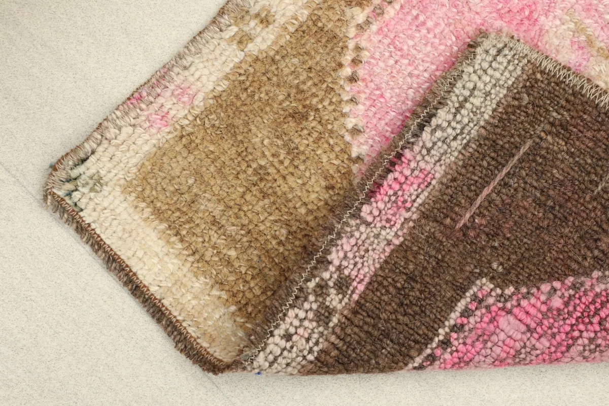 Partially folded rug displaying the wool pile on the front and cotton foundation on the back