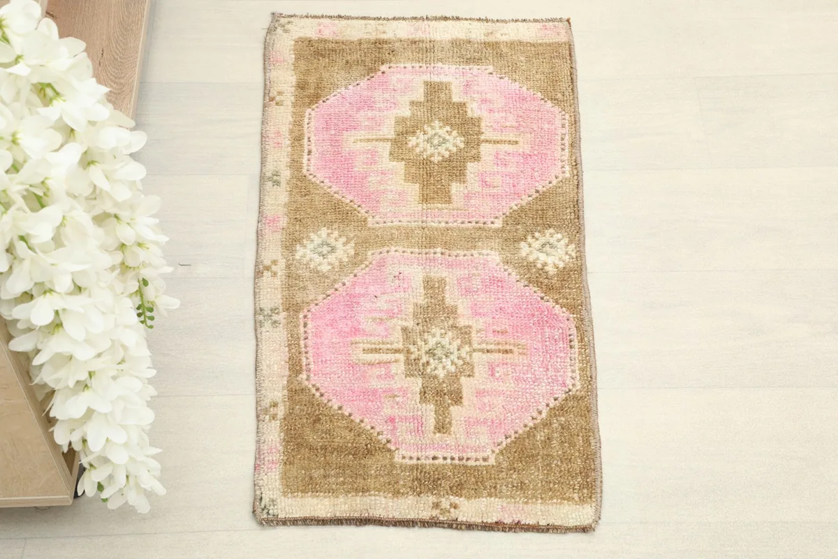 Overhead view of the hand-knotted wool rug, showcasing its pink and brown geometric design