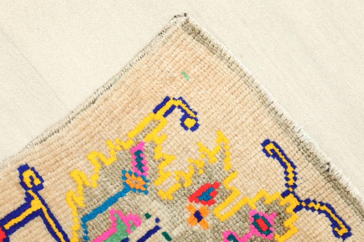 Detail of the top-left corner of the rug, showing the finished edge and a portion of the design.