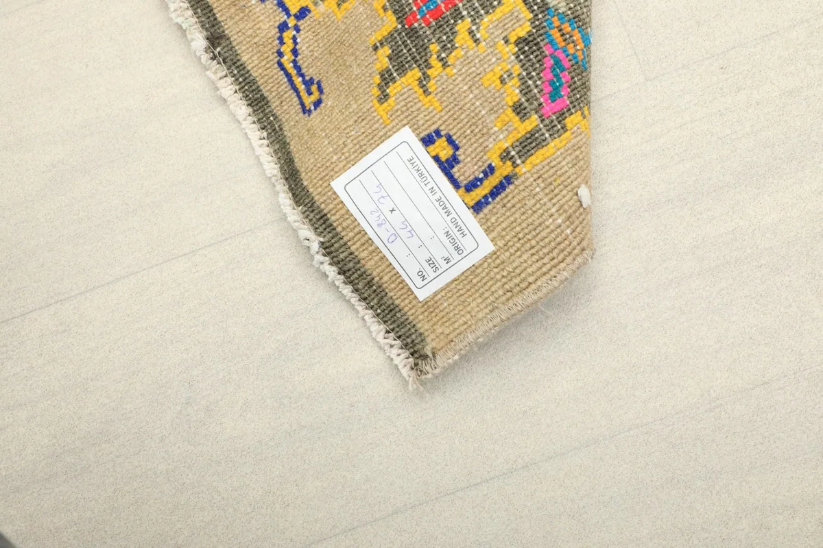 View of the backside of the rug with a label, showing the tight knotting on the cotton foundation.