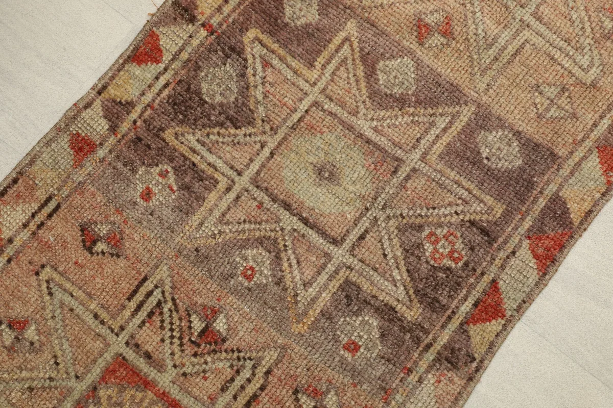 Close-up detail of the central geometric star motif in tan and rust colors.