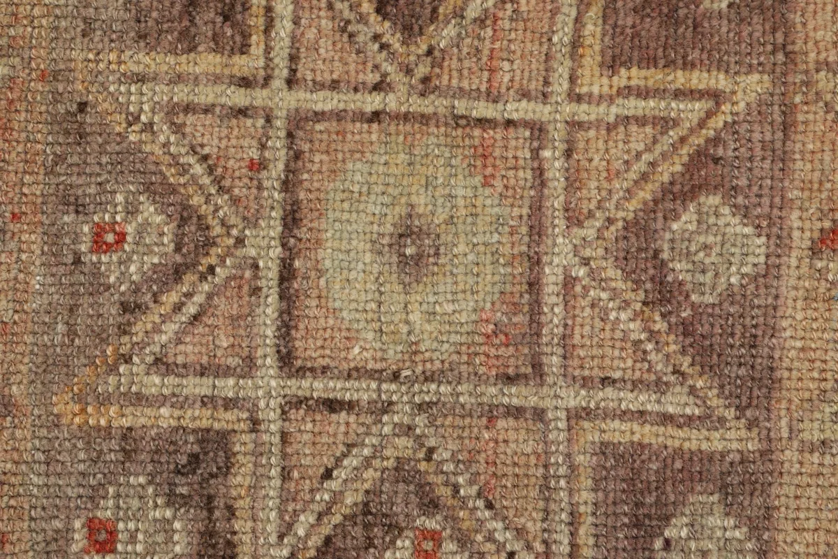 Detailed view of the hand-knotted wool pile and intricate geometric pattern.