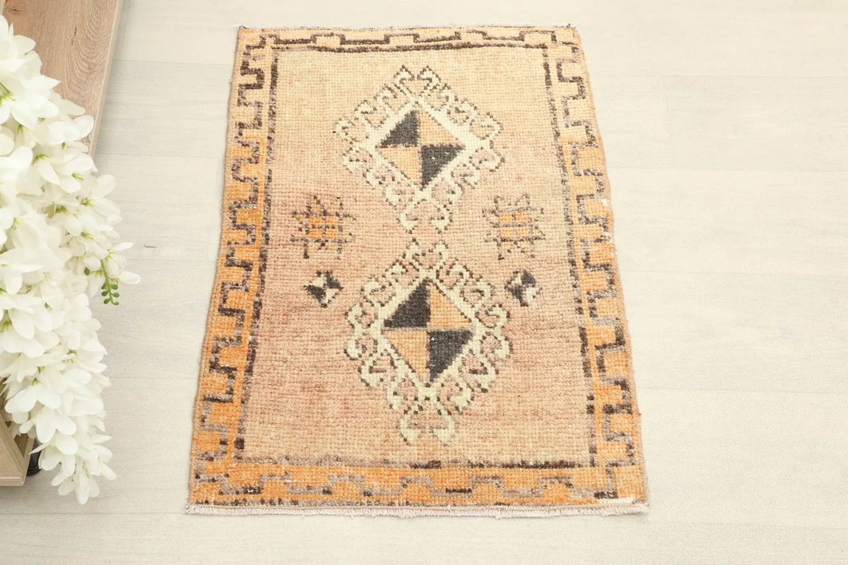 Direct overhead shot showcasing the full design of the tan field with geometric diamond motifs and orange border.