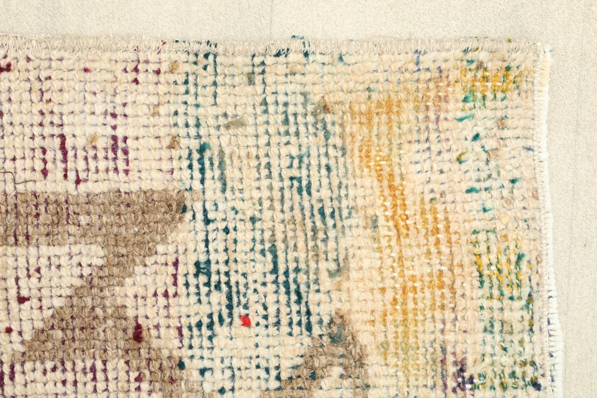 Close-up of the rug's edge, highlighting the hand-knotted construction and subtle color variations.
