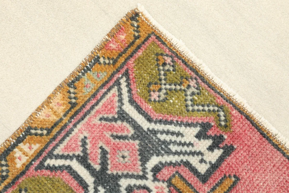 Corner detail showing the rose field, tribal motifs, and the gold-toned border.