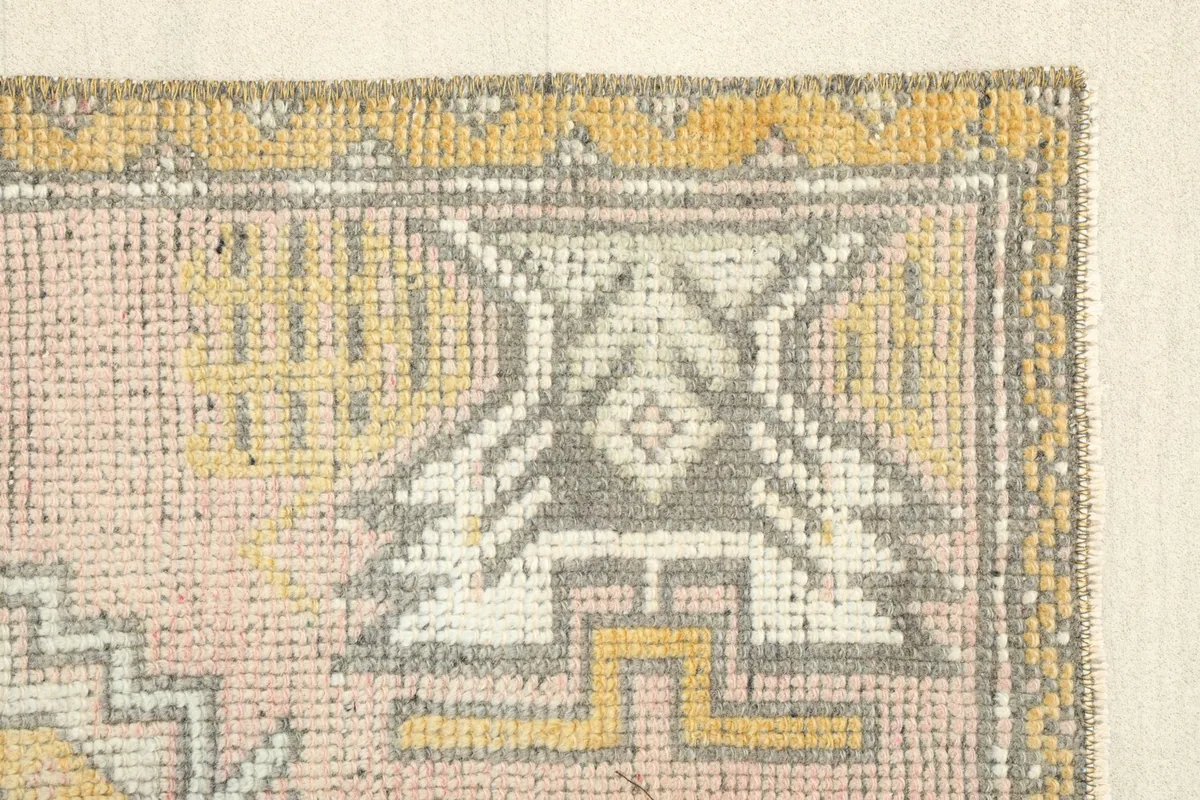 Close-up of a corner motif, highlighting the gray, white, and yellow tribal patterns