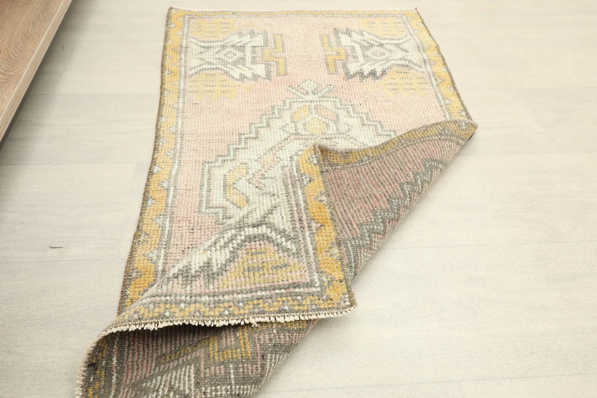 The vintage rug partially folded, showcasing its flexibility and back side