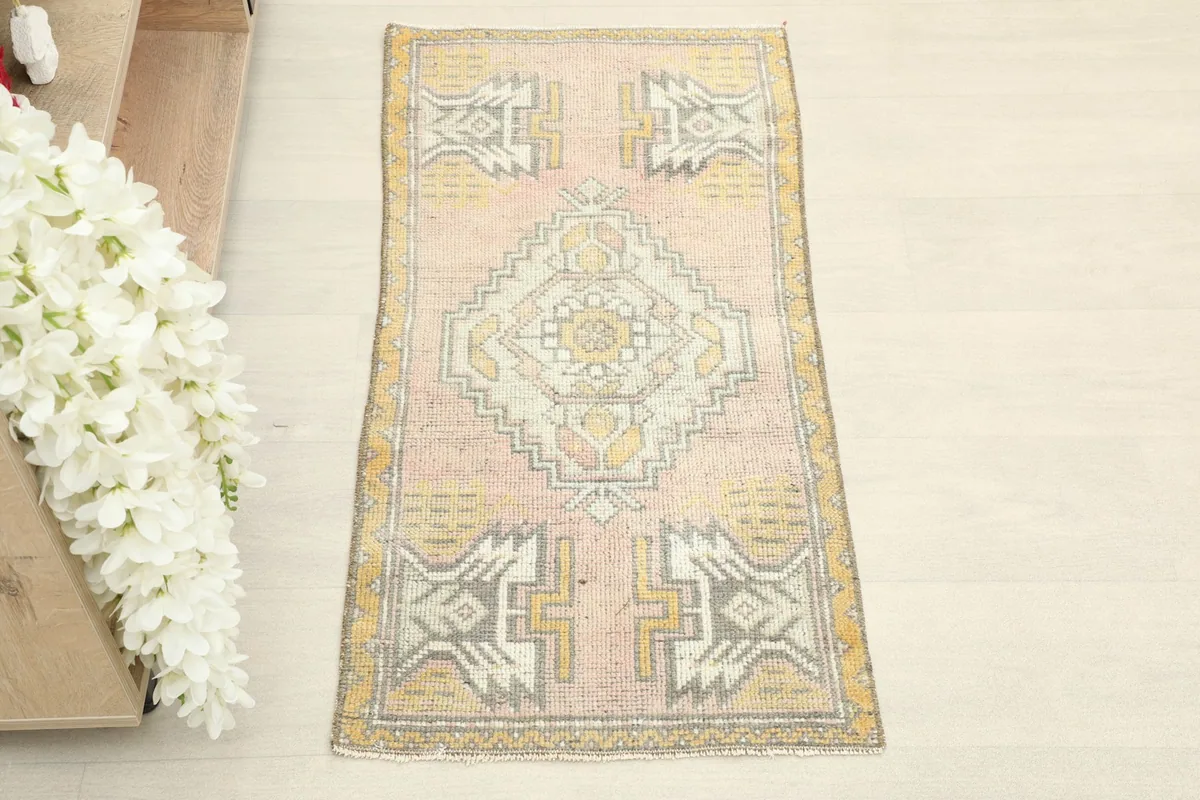 Overhead view of the vintage pink and yellow rug with tribal geometric patterns