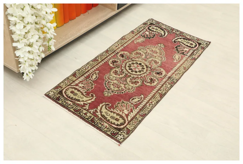 Full top view of the vintage rose Anatolian doormat with central medallion and paisley motifs