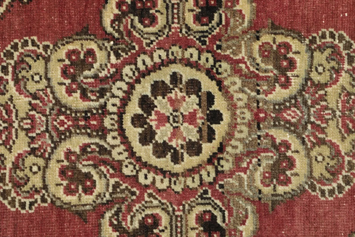 Detailed view of the rug's knotting and the intricate patterns in beige, brown, and black