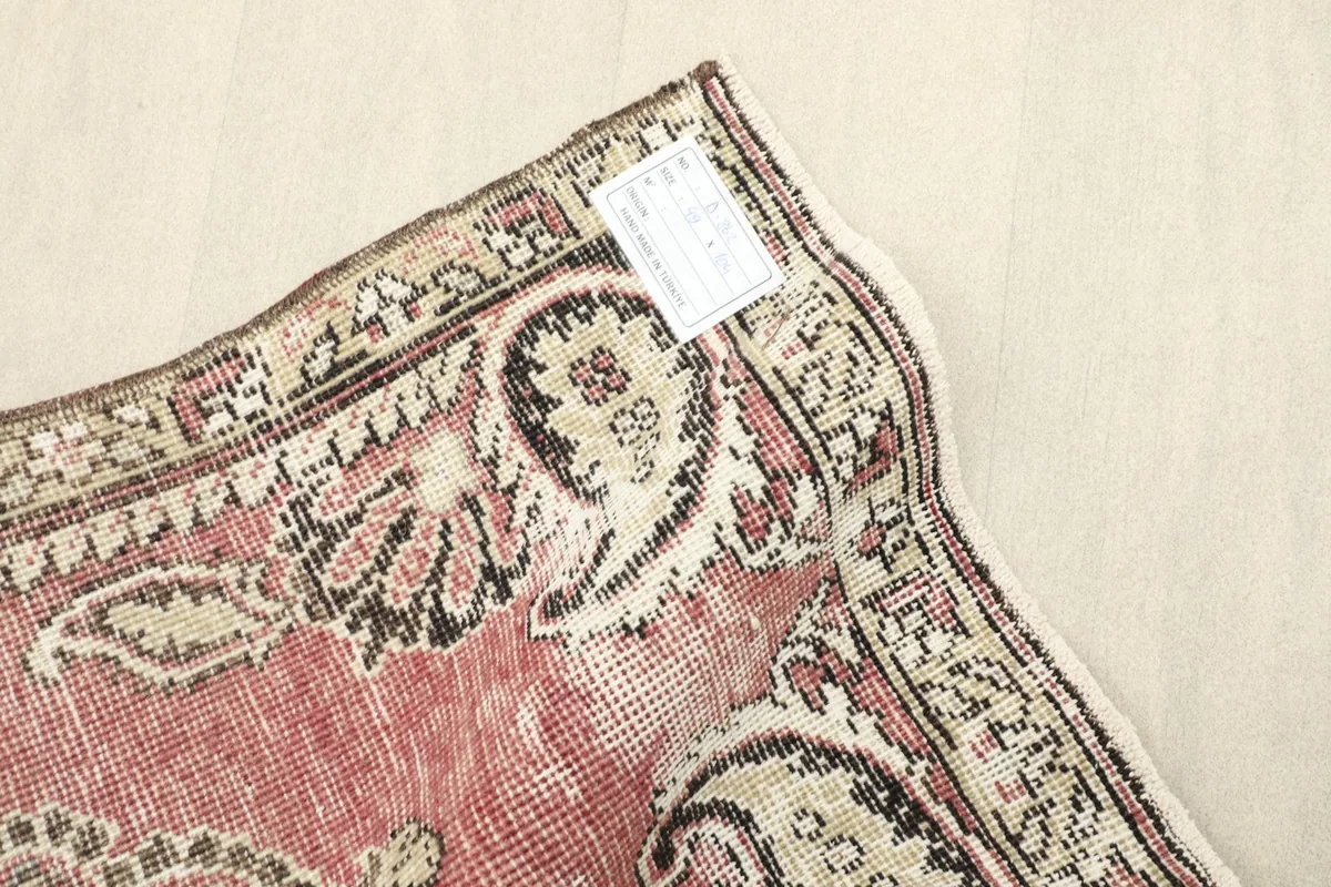 Close-up of the low wool pile and the worn patina of the vintage hand-knotted rug