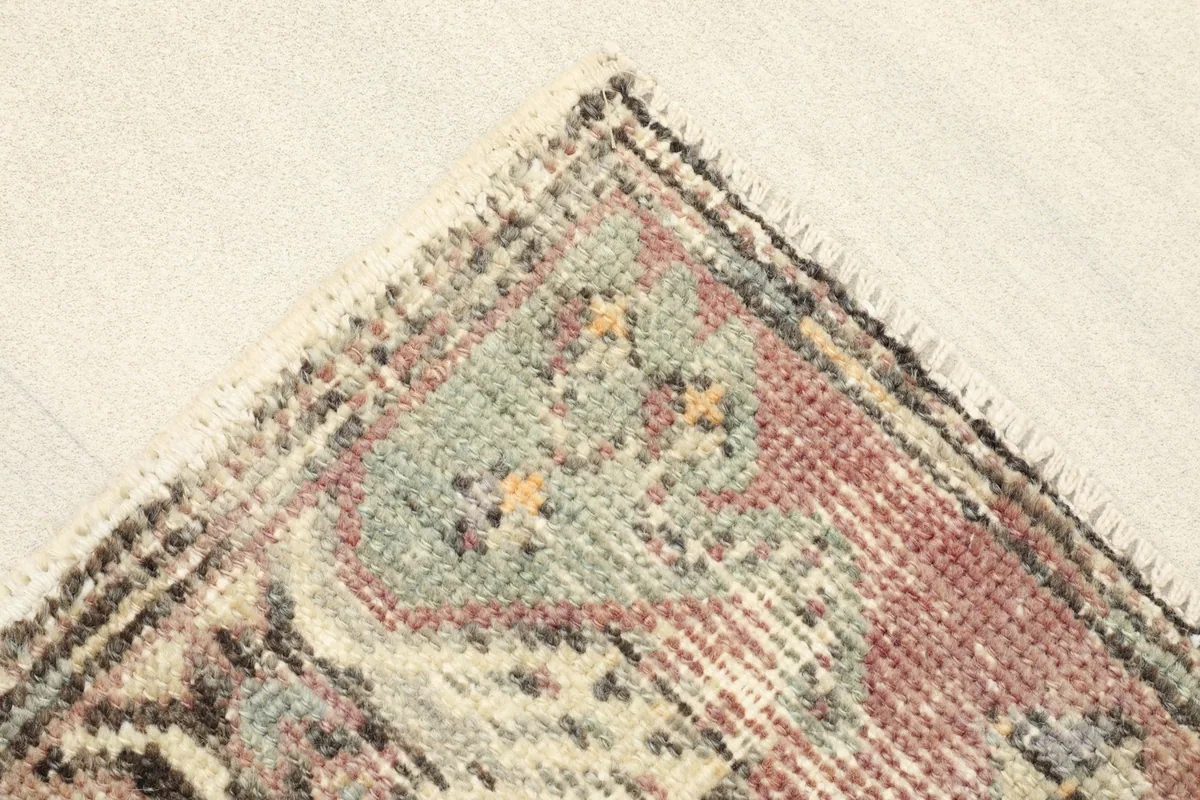 Close-up of a corner showing the green and ivory tribal patterns and edge finishing.