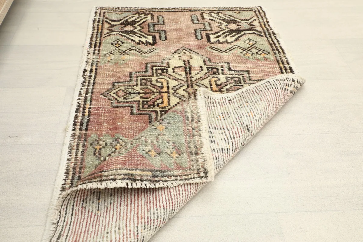 Rug partially folded, displaying the full design and the woven back.