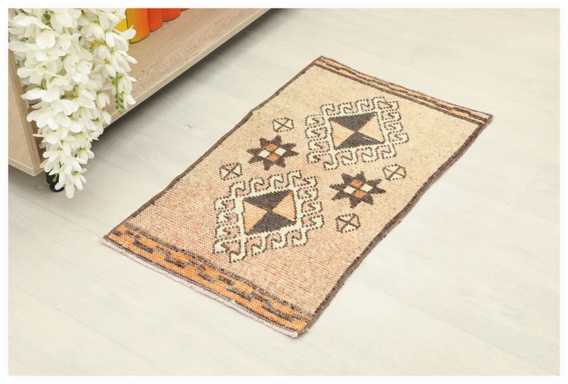 Full overhead view of the 1'5" x 2'6" vintage Anatolian doormat on a white background