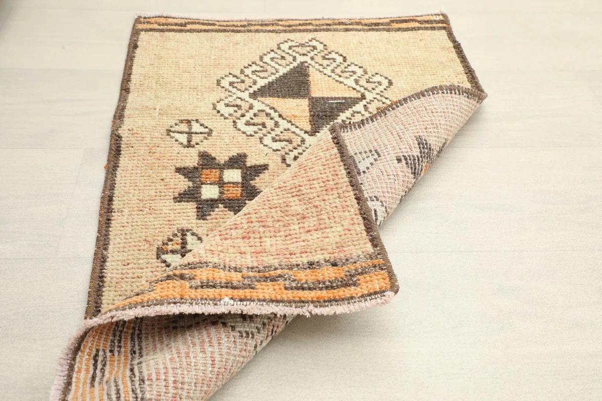 Angled view of the rug partially folded, displaying the back of the cotton foundation