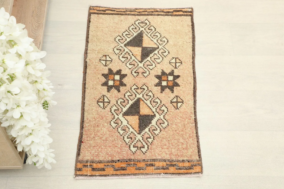 Direct overhead shot of the hand-knotted tan rug, showcasing its tribal geometric patterns