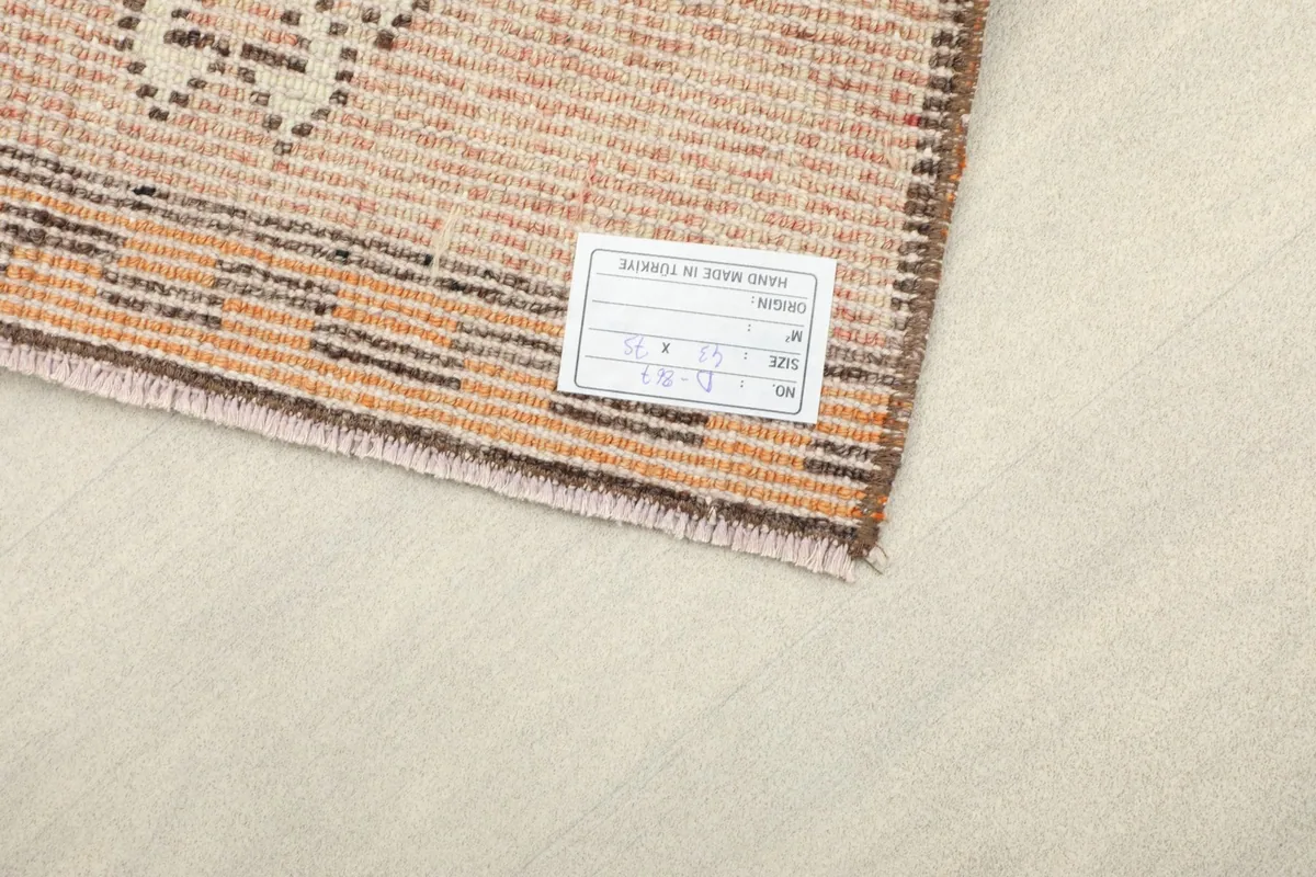 Close-up of the rug's back with a size and origin label attached, showing the quality of the weave