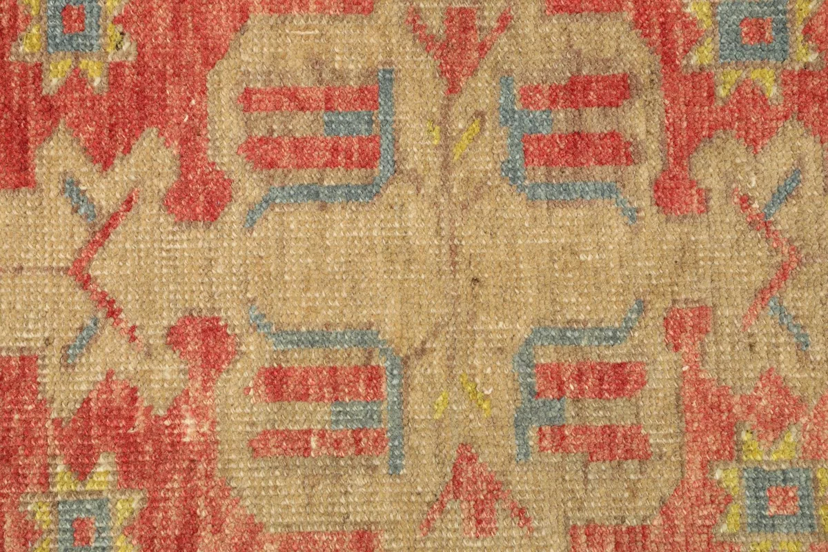 Detailed view of the hand-knotted pile and specific tribal patterns in the rug's center.