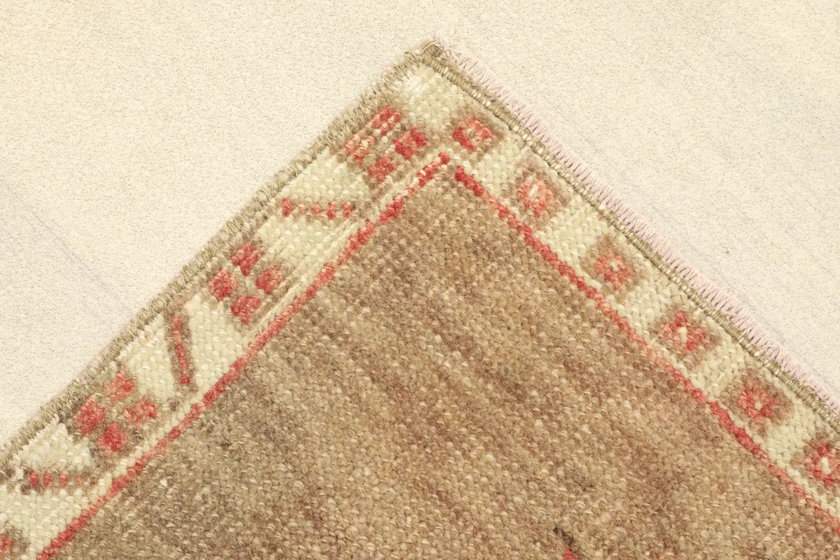 Corner view showing the reverse side of the rug, revealing the cotton foundation and knotting.