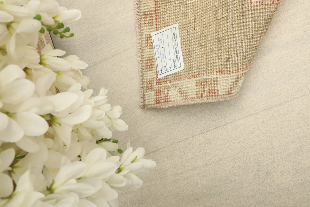 Close-up of the rug's reverse side, showing the hand-knotted construction and a product tag.