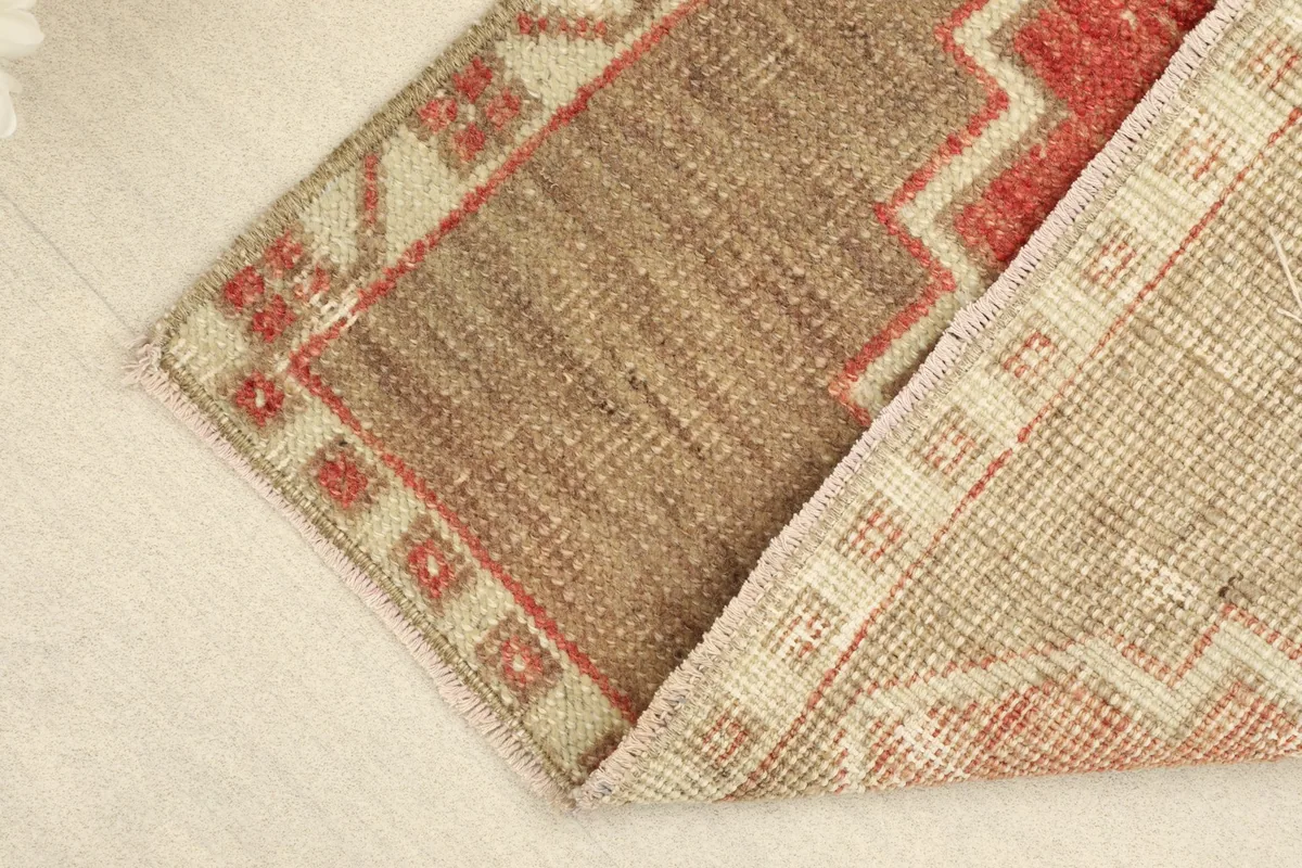 View of the rug folded to show both the front and back, emphasizing the low pile and tight weave.