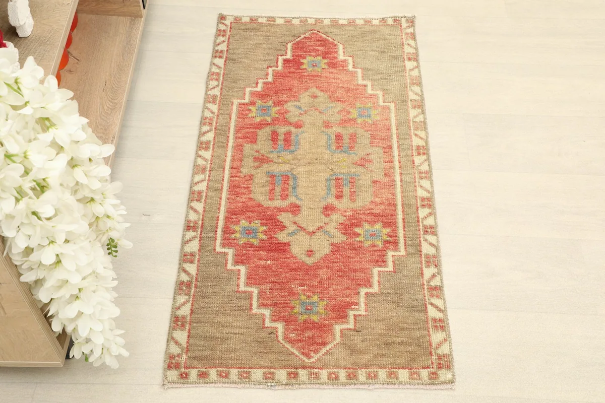 Direct overhead shot of the hand-knotted wool rug, showing its central rust medallion and tan field.