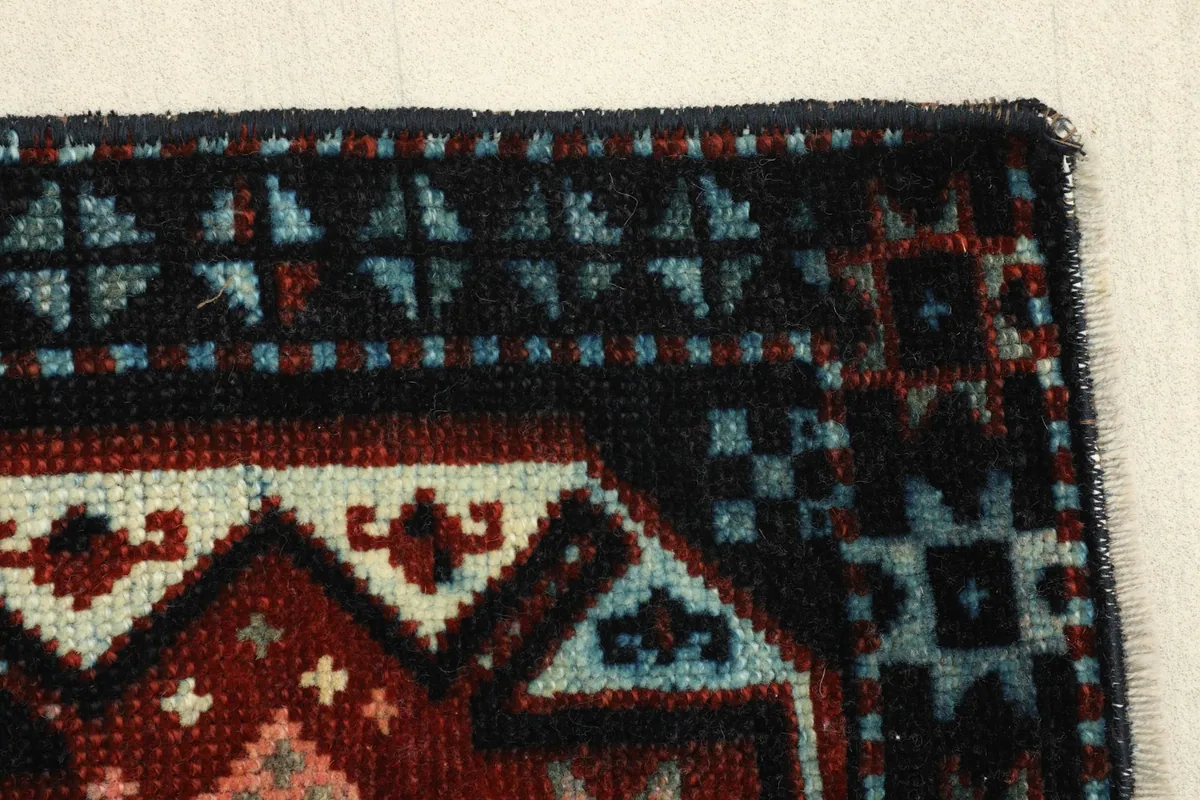 Detailed view of the rug's edge, showcasing the wool pile and varied colors