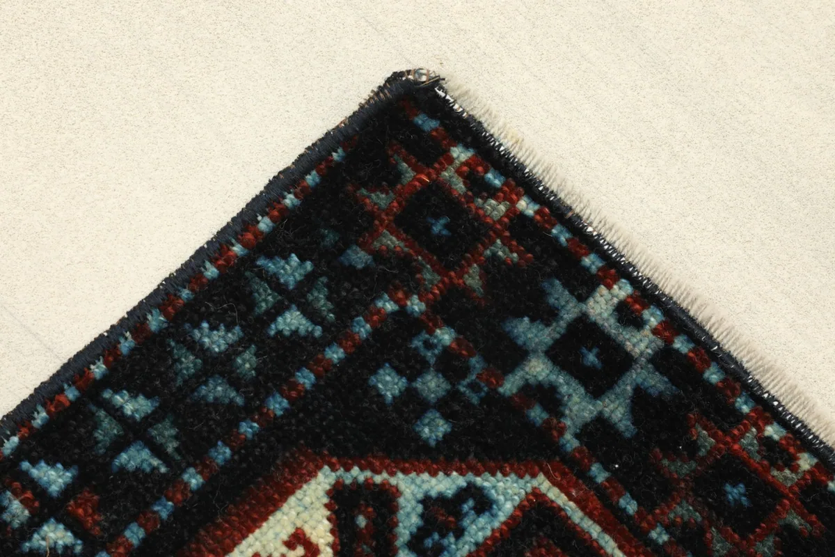 Corner detail showing the intricate geometric border design and tight knotting