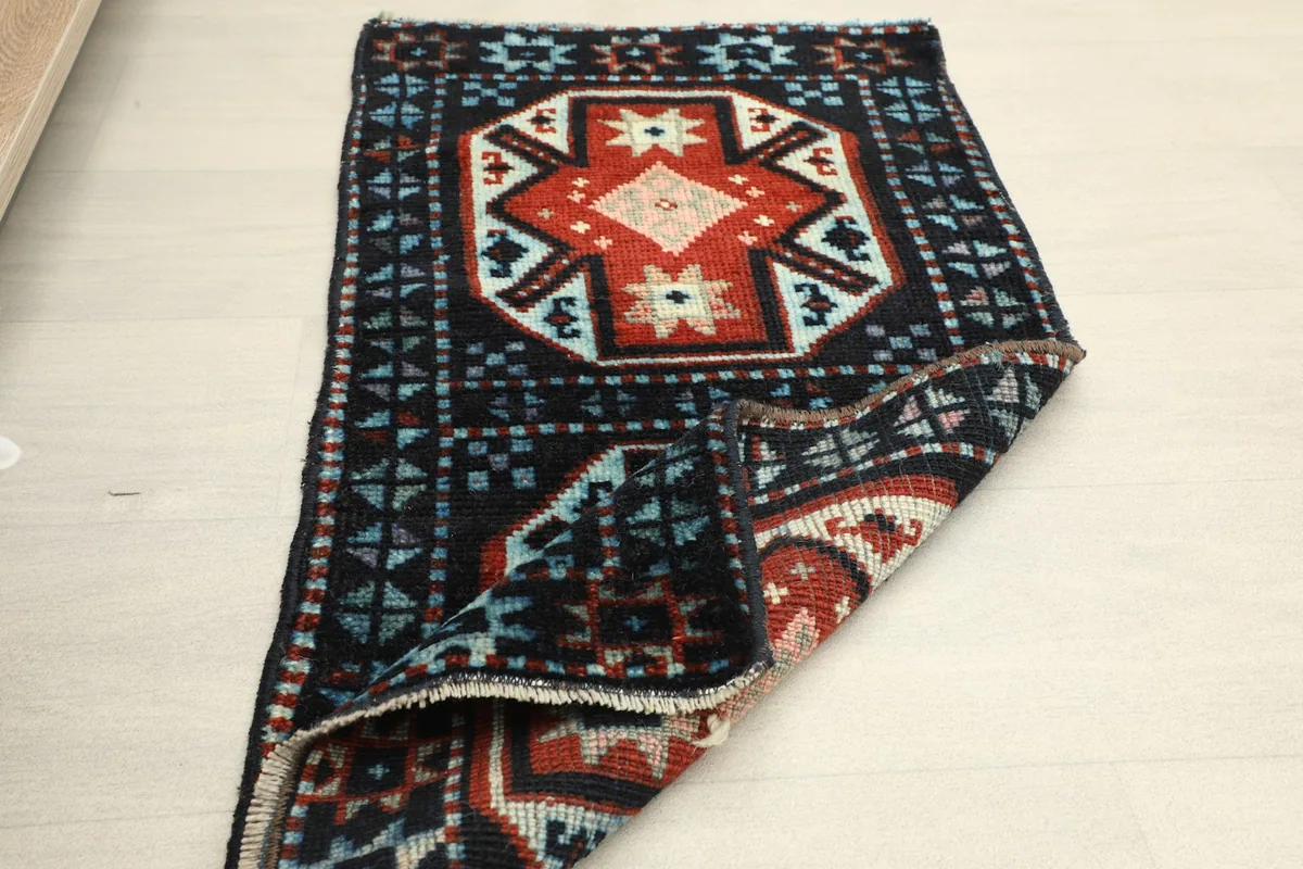 Partial fold of the rug, showing its flexibility and the back of the weave