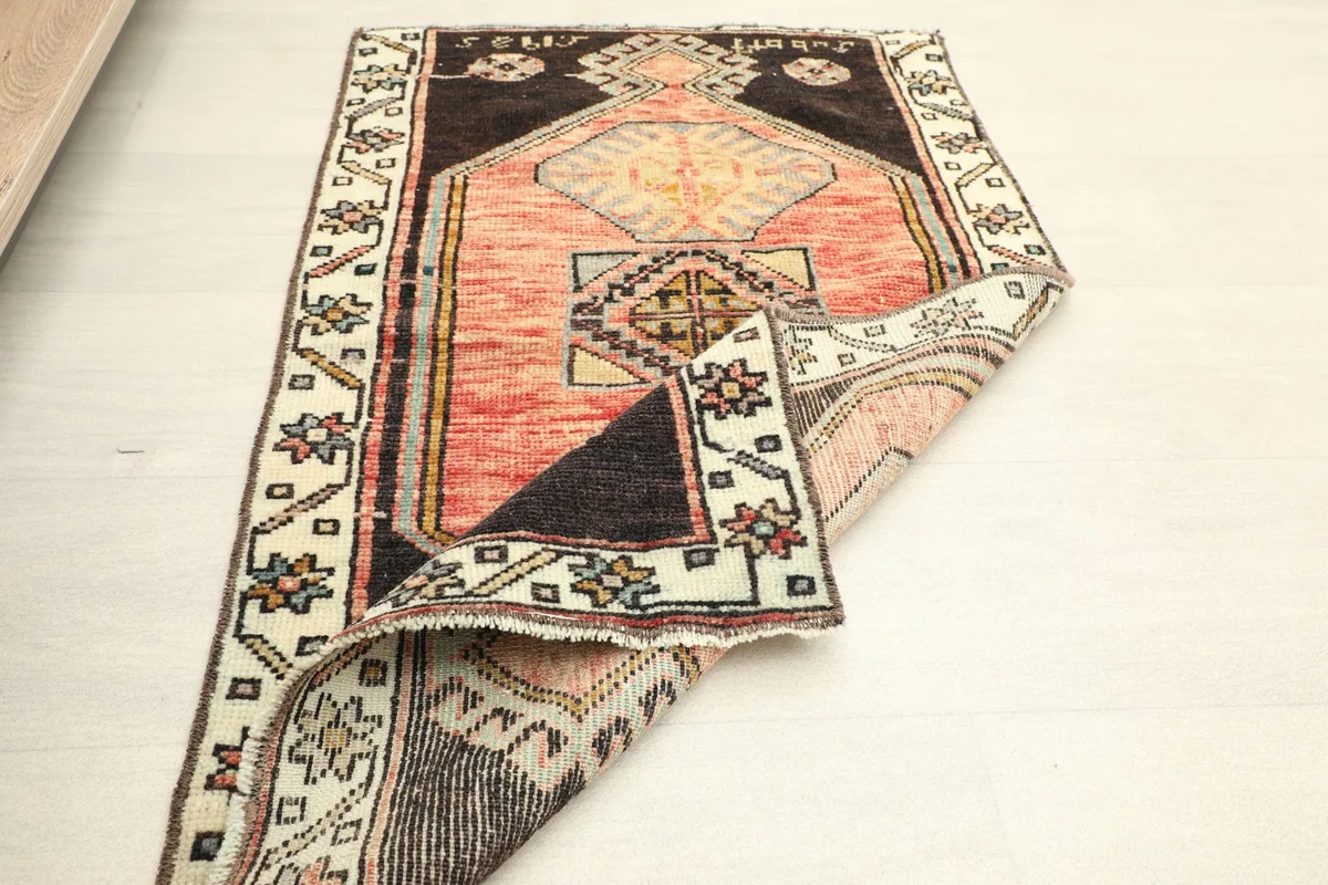 Angled view of the rug partially folded, illustrating its size and texture.