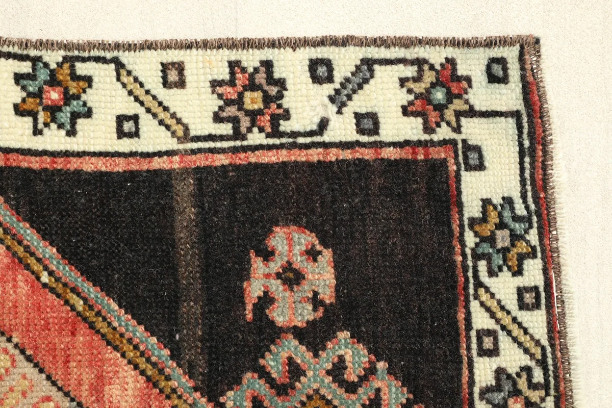 Detail of the top right corner, highlighting the ivory border design and the black field.