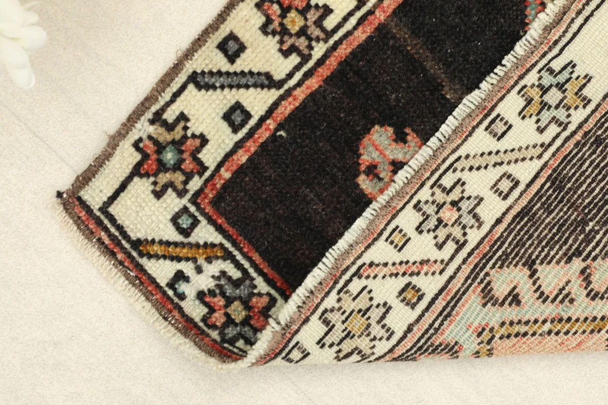View of the rug folded to show the thickness and the fringe detail on one end.