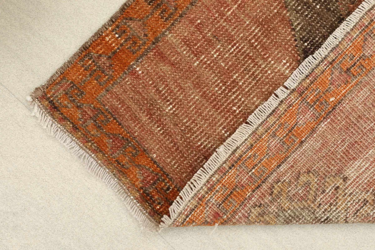 View of the rug's reverse side, showing the hand-knotted cotton foundation and wool pile.