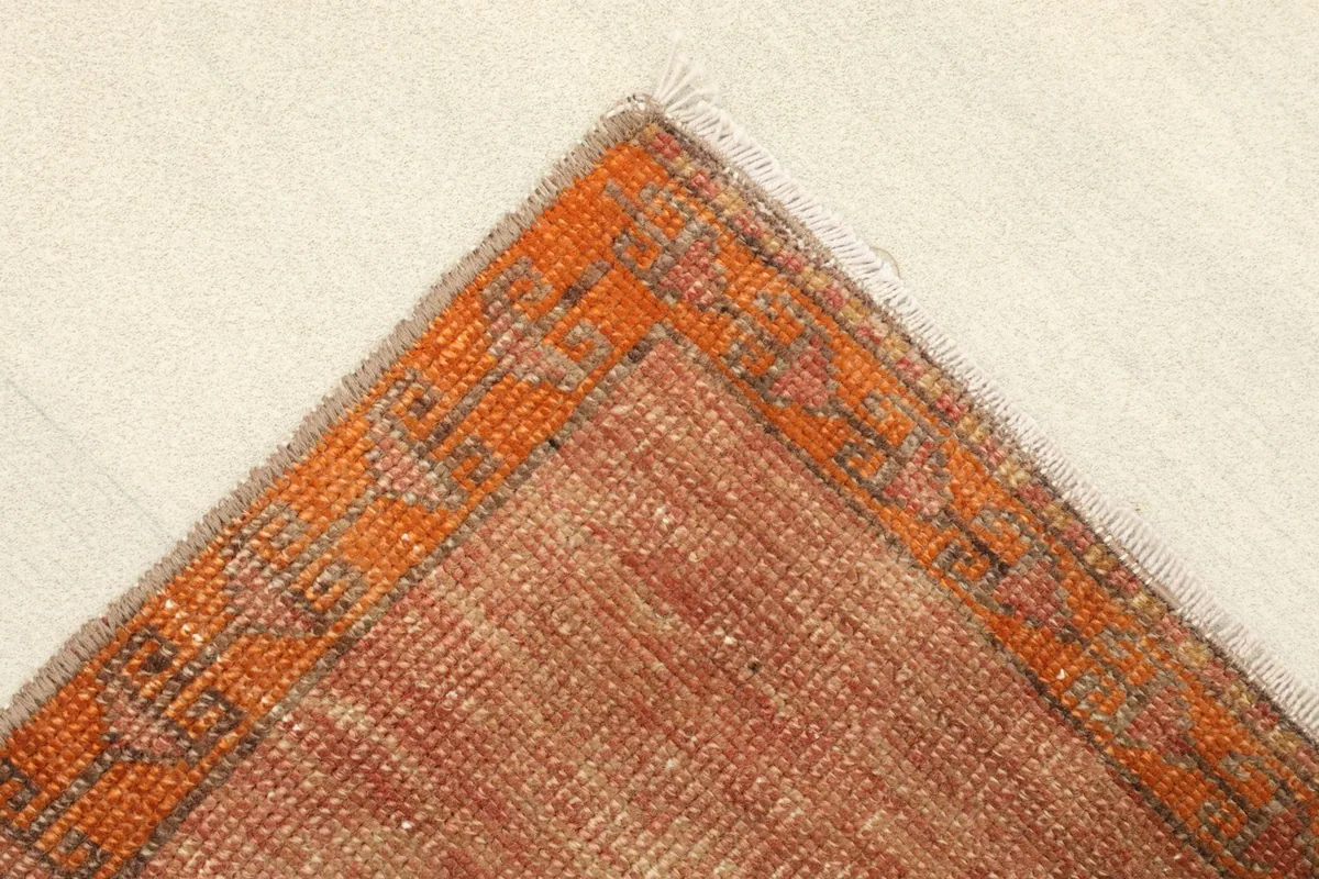 Folded corner of the rug, showing the wool pile and cotton foundation.