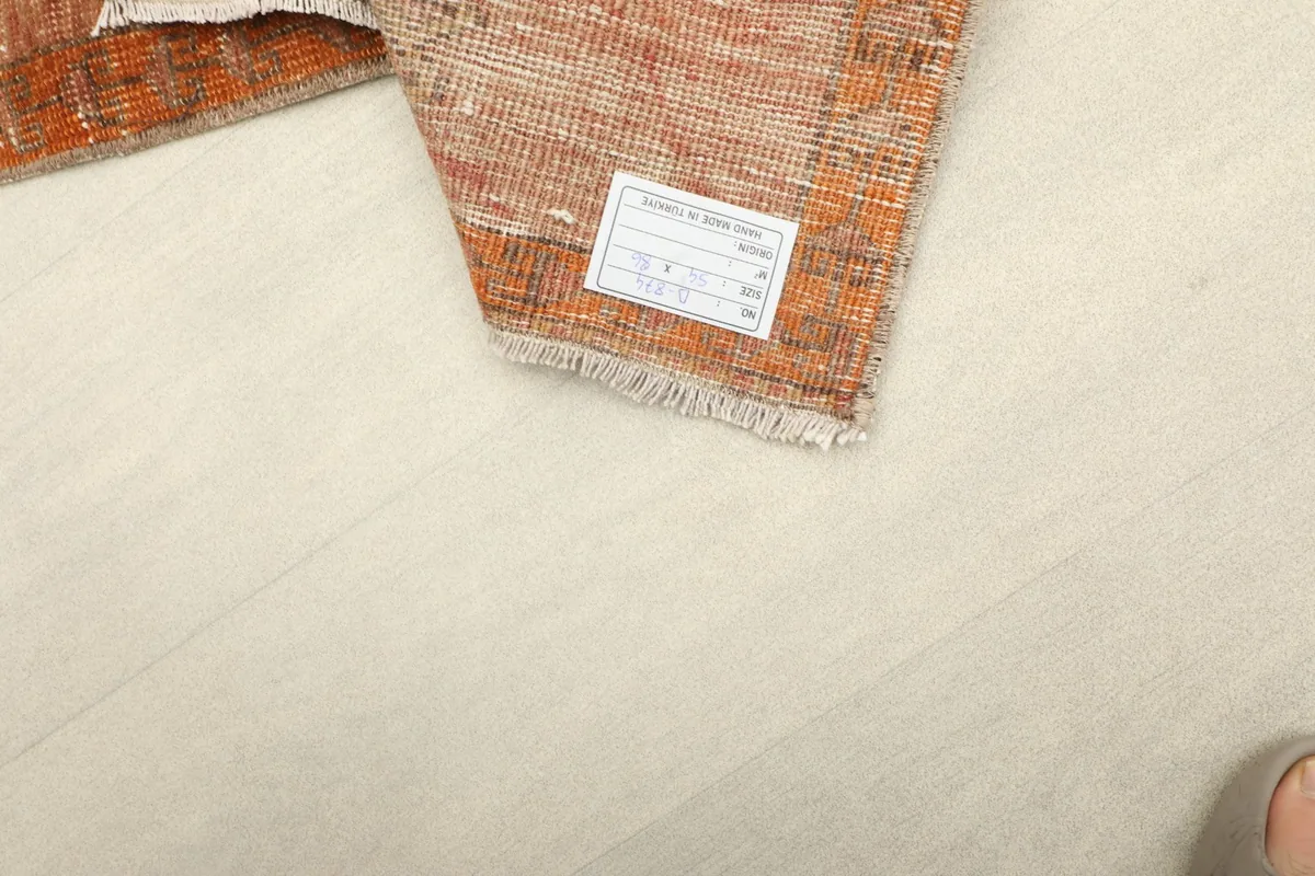 Close-up of the care label attached to the back of the vintage hand-knotted rug.