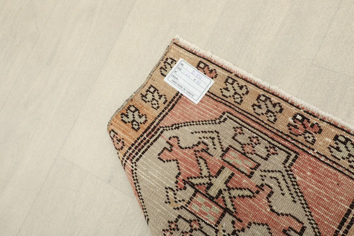 Detail of the rug's back, revealing the hand-knotted construction and the label.
