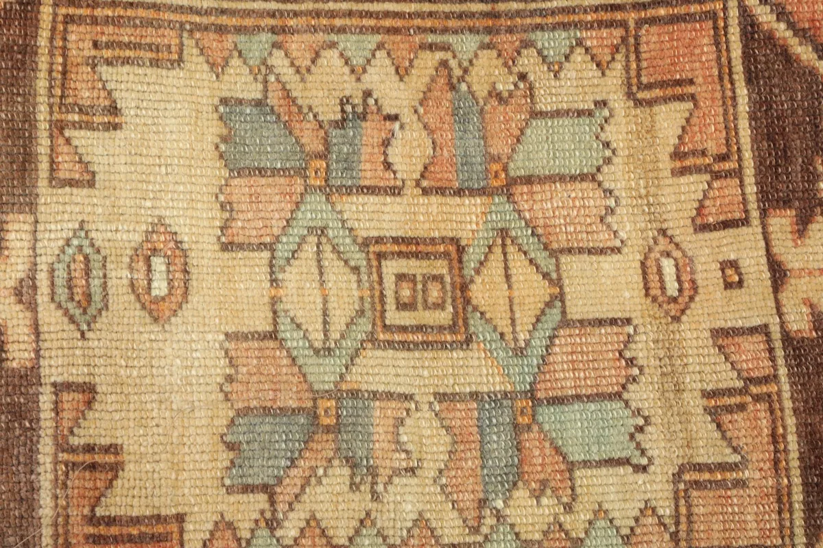 Close-up detail of the intricate geometric motifs and color variations in the rug's pile.
