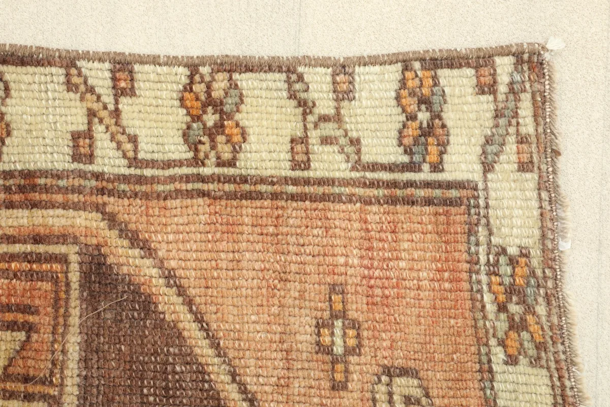 Close-up of the rug's edge, revealing the hand-knotted texture and color transitions.