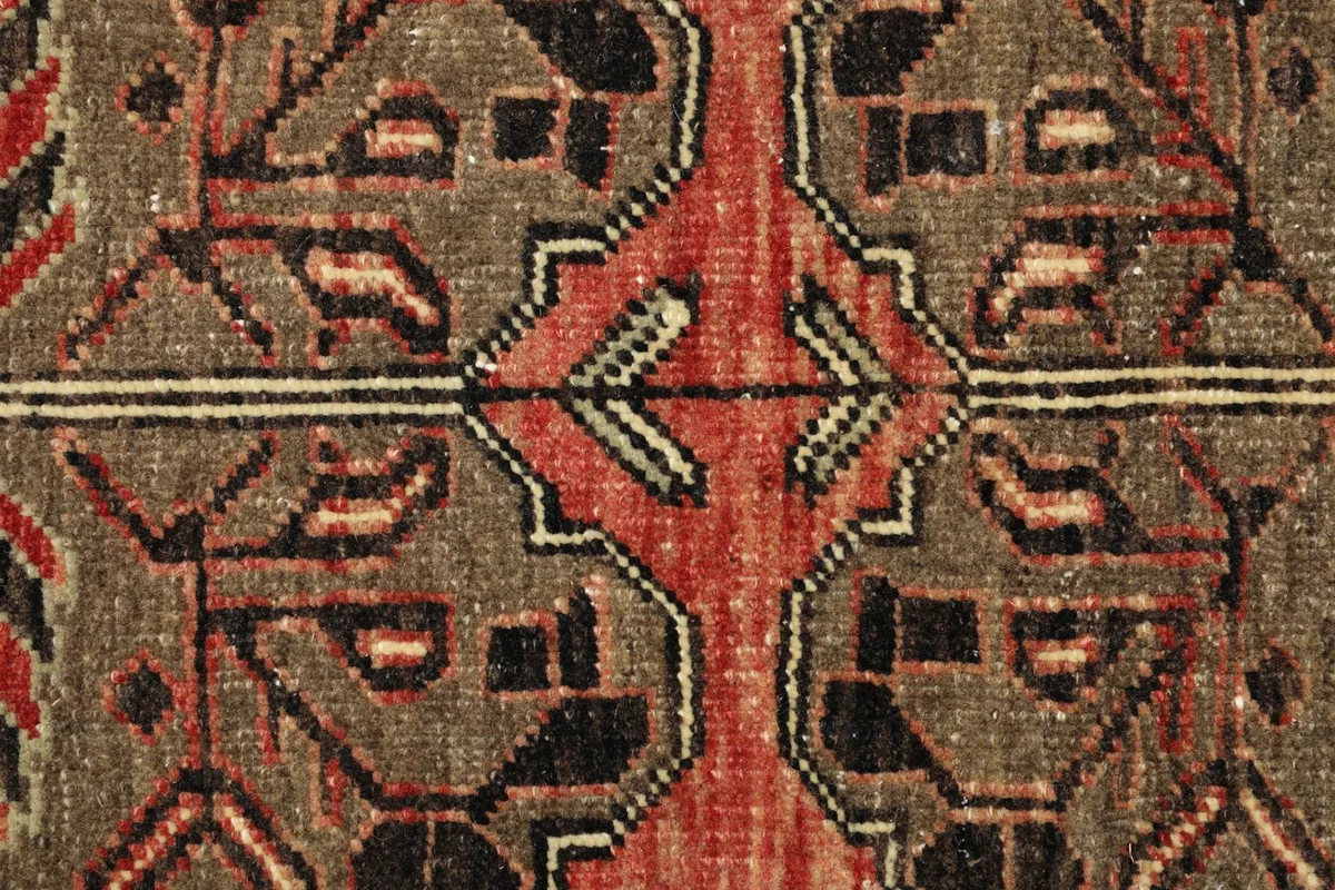 Close-up detail of the hand-knotted wool pile, showing the distinct geometric motifs and color variations.