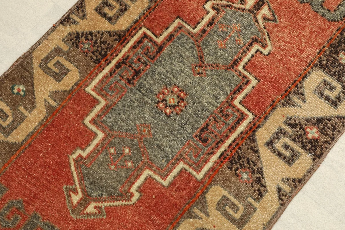 Close-up detail of the central gray geometric medallion with rust and brown accents.