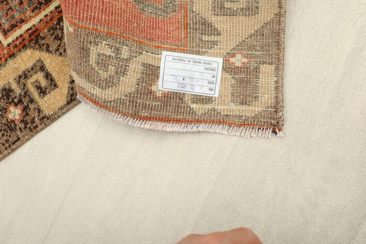 Underside of the rug, displaying the cotton foundation and a small tag.