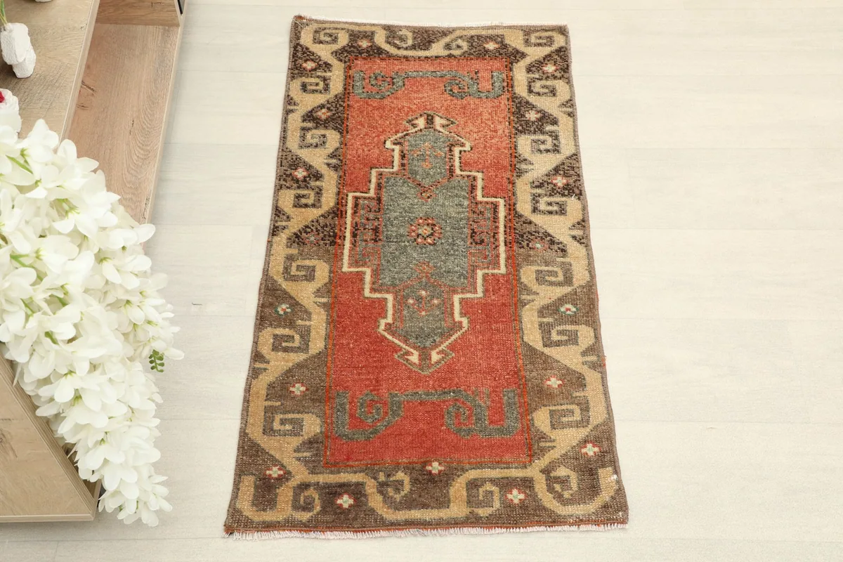 Overhead shot of the small hand-knotted rug, showing its full design and color variation.