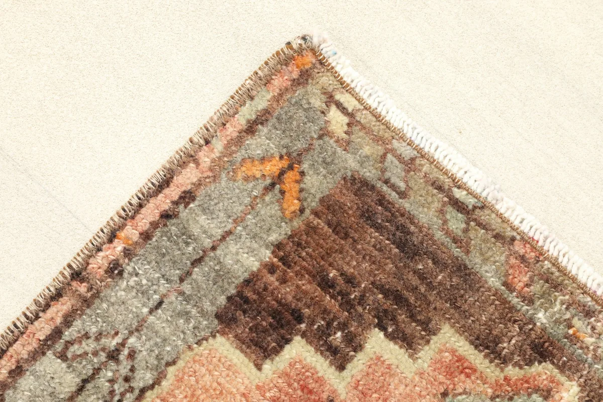 Close-up of a corner, illustrating the rug's border design and the quality of the wool pile.
