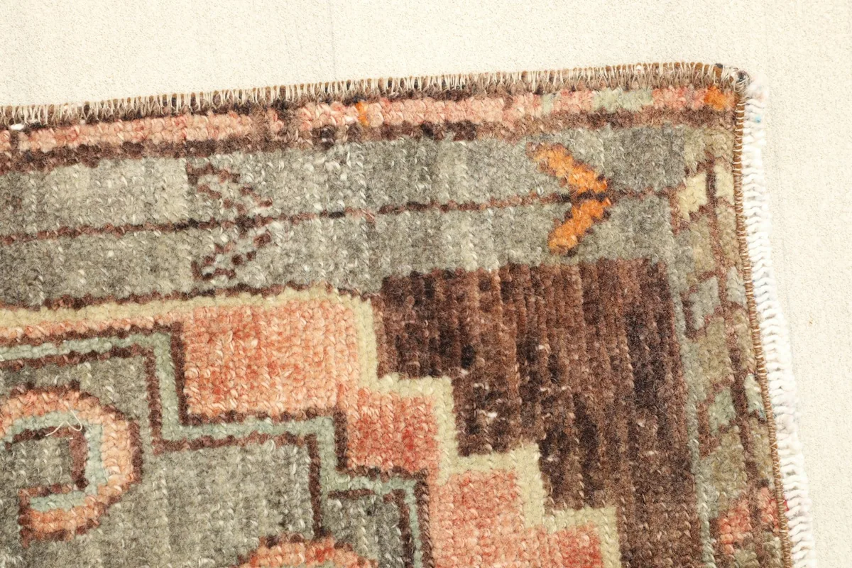 Side view of the rug's low pile, revealing the texture and slight variations in the vintage wool.