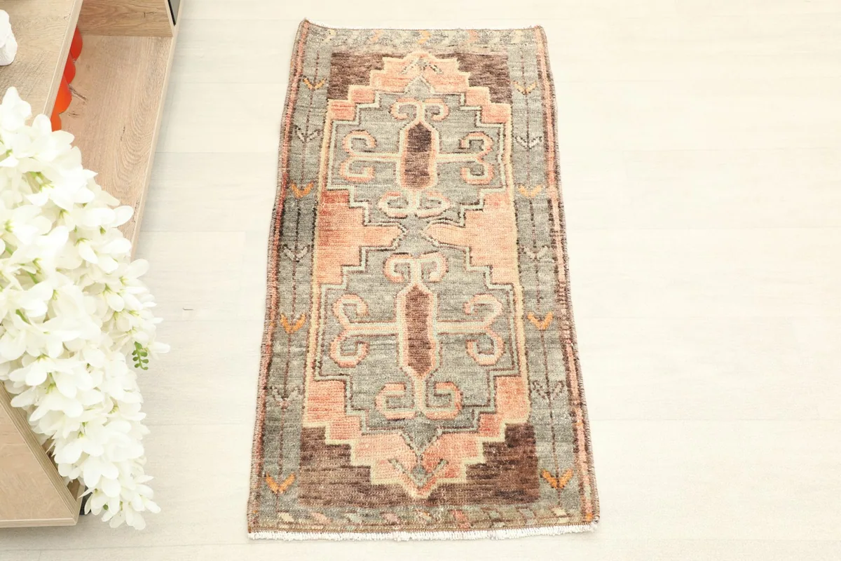 Overhead view of the hand-knotted wool rug, highlighting the central geometric motif and border.