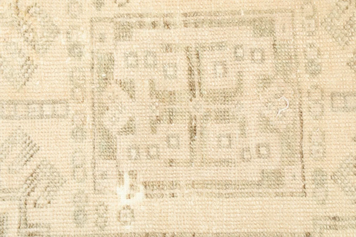 Close-up detail of the central geometric motif and the subtle color variations in the rug.