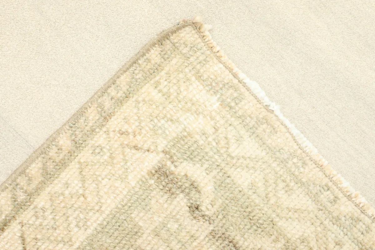 Corner detail showing the woven border design and the low pile of the vintage rug.