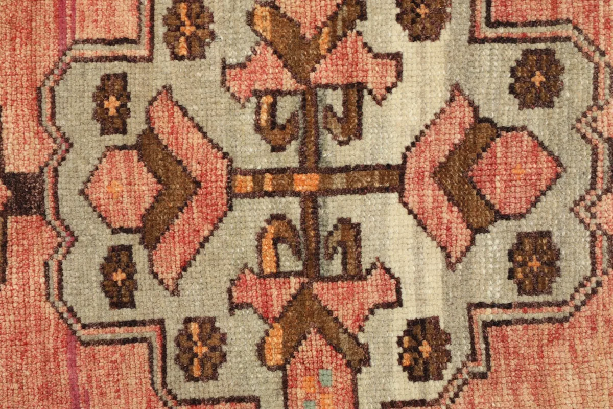 Tight detail shot focusing on the intricate hand-knotted patterns and color variations within the rug.